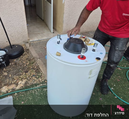אדם עובד על דוד שמש בחצר